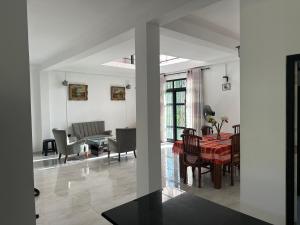 Un comedor y una sala de estar con mesa y sillas. en Bamboo Tree Villa, 