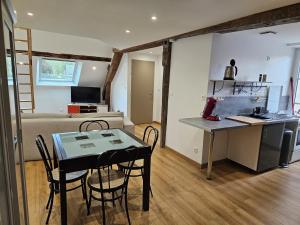 a room with a kitchen and a table and a bed at Un duplex lumineux in Mer