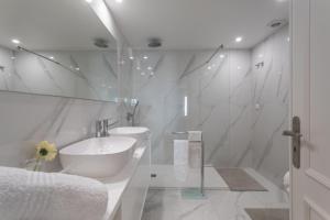 a white bathroom with a tub and a sink at BeGuest Jardim Quinta da Alagoa Luxury Stay in Carcavelos +20 photos