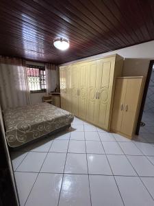 a bedroom with a bed and cabinets in it at Sítio Vô Leno in Biguaçu