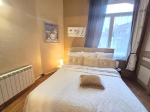 a bedroom with a large white bed with a window at Villa Seven 2 in Dunkerque