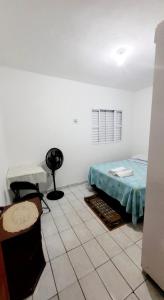 a bedroom with a bed and a table and a chair at Casa Aeroporto a poucos minutos do Aeroporto de Viracopos in Campinas