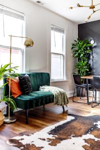 um sofá verde numa sala de estar com plantas em Short North Convention Private Parking Pets! em Columbus
