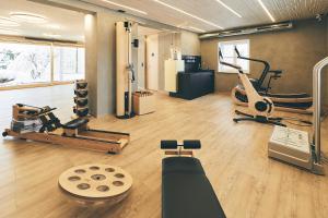 a gym with two exercise bikes and a treadmill at Gesundheitshotel König in Grünenbach