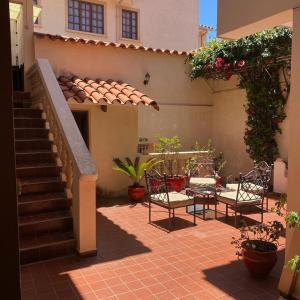 a patio with a table and chairs and a staircase at B&B SANTA CECILIA in Sucre