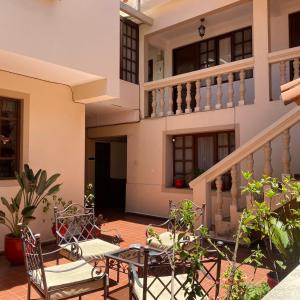 a patio with chairs and a table in front of a building at B&B SANTA CECILIA in Sucre