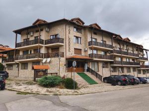 een groot gebouw met auto's ervoor geparkeerd bij Apartament 4 seasons - Top Lodge in Bansko