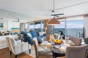 a living room with a blue couch and a table at Hololani A204 in Kahana