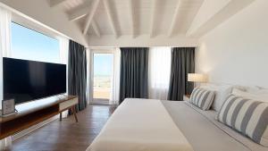 a bedroom with a large bed and a large television at Terrazas Al Mar in Pinamar