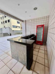 a red drink dispenser in a room with a counter at LK Barro Preto 1 in Belo Horizonte