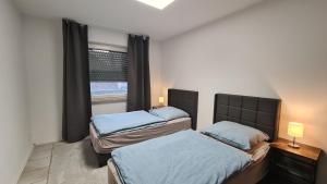Un dormitorio con dos camas y una ventana. en Gästehaus Wohnung #3, en Julich