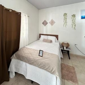a bedroom with a bed with a tablet on it at La ceiba surf in El Sunzal +15 photos