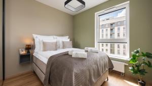 ein Schlafzimmer mit einem Bett und einem Fenster in der Unterkunft Flatbook - Seaside Apartments Nowa Letnica with a Rooftop Viewing Terrace & Gym II in Danzig