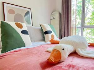 a stuffed goose is laying on top of a bed at Minimalist Oasis - Monthly Stay Near Airport, Local Gems & Mall - Minimum Stay 28 Days in Bangkok +13 photos