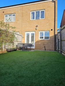 une maison avec une pelouse devant un immeuble dans l'établissement Spacious 3-Storey Home from Home in Hetton le Hole, à Hetton le Hole