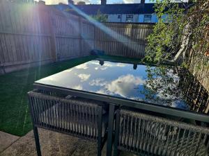 une table avec le reflet du ciel dans un étang dans l'établissement Spacious 3-Storey Home from Home in Hetton le Hole, à Hetton le Hole