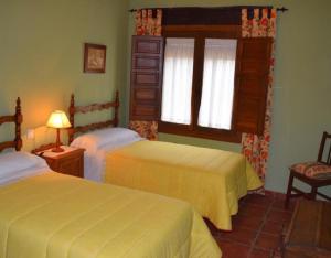 a bedroom with two beds and a window at Casa Rural La Era in Aldeanueva de Barbarroya