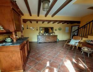 a large room with a kitchen with a table at Casa Rural La Era in Aldeanueva de Barbarroya +13 photos