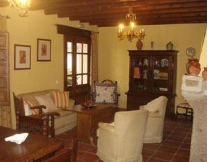 a living room filled with furniture and a chandelier at Casa Rural La Era in Aldeanueva de Barbarroya
