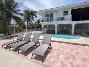 a group of chairs sitting in front of a house at Tropical Sunsets in Marathon