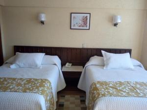 a hotel room with two beds with white sheets at Hotel Rio Nazas in Torreón +6 photos
