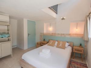 een slaapkamer met een wit bed in een kamer bij vakantiewoning Emponse 7 in Plan-de-la-Tour +34 foto's