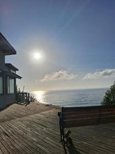 un banco sentado en un paseo junto al océano en Maravillosa vista, en Mirasol