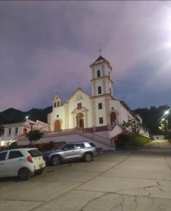 a church with two cars parked in front of it at Manawa Kaona in Somondoco +3 photos