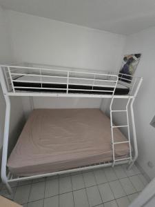 ein leeres Etagenbett in einem kleinen Zimmer in der Unterkunft Cap d'Agde - T2 lumineux piscine et tennis in Cap d'Agde