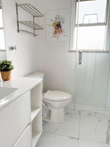 Un baño blanco con inodoro y ducha. en Vivi's Home, en Vancouver 6 fotos más