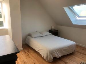 una piccola camera da letto con un letto e una finestra di Menbleis, maison familiale a Plounéour-Trez