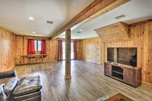 a living room with a couch and a large television at Wander & Unwind Log Cabin And Suites At Equestrian House in Pleasant Mount