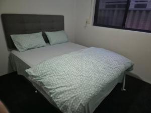 a bed in a small room with avertisement at Dalyellup 2BR accommodation-Rear Guest house Unit- Walkable to major supermarkets in North Boyanup