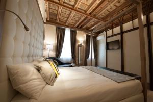 a bedroom with a large bed with a white headboard at Residenza Bonifacio - Adults Only in Verona