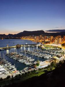 a marina with boats in the water at night at Apartamento Aquarium Park, 1ª linea de playa, piscina privada, aire acondicionado y wifi de alta velocidad in Calpe