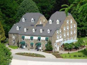 a large stone building with a black roof at Moulin de Daverdisse in Daverdisse