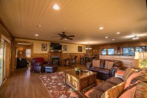 a living room with leather furniture and a ceiling fan at Alpine Vista in Blowing Rock