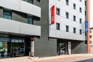 a building with a red sign on the side of it at Ibis Lugano Paradiso in Lugano