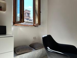 a black chair in a room with a window at Residenza Aurea Tivoli in Tivoli
