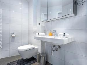 a white bathroom with a toilet and a sink at Superior Studio at St Stephen's Cathedral City Center - 1 min walk to Vienna City Center in Vienna