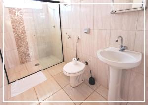 a bathroom with a shower and a toilet and a sink at Hotel Europa in Barra Bonita