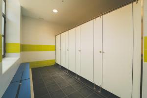 メキネンサにあるTres Estrellas Mequinenzaの白いキャビネットとタイル張りの床を備えたロッカールーム