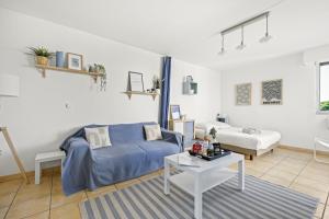 ein Wohnzimmer mit einem blauen Bett und einem Sofa in der Unterkunft Piscine & Soleil à Hyères - T3 spacieux avec Clim & Extérieurs in Hyères + 29 Fotos