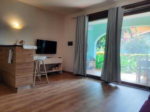 Porto Antigo 2 Beach Club 18 في سانتا ماريا: غرفة معيشة مع نافذة كبيرة وتلفزيون