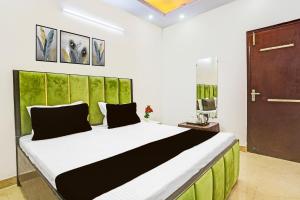 a bedroom with a large bed with a green headboard at Hotel O Yash stay in New Delhi