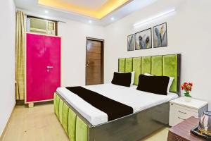 a bedroom with a large bed with a red door at Hotel O Yash stay in New Delhi