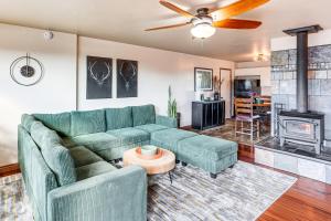 a living room with a green couch and a fireplace at Hike and Golf Farmington Home 1 Mi to Animas River! in Farmington