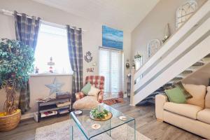 a living room with a couch and a staircase at Host & Stay - The Cheeky Squirrel in New Brighton +21 photos