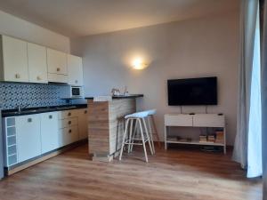 Porto Antigo 2 Beach Club 18 في سانتا ماريا: مطبخ مع كونتر وتلفزيون على الحائط