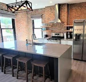a kitchen with a large island with bar stools at Short North Convention King Bed Free Parking! in Columbus +20 photos